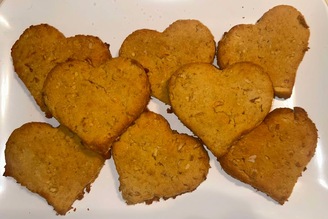 Heart shape apple natural dog treats on a white plate