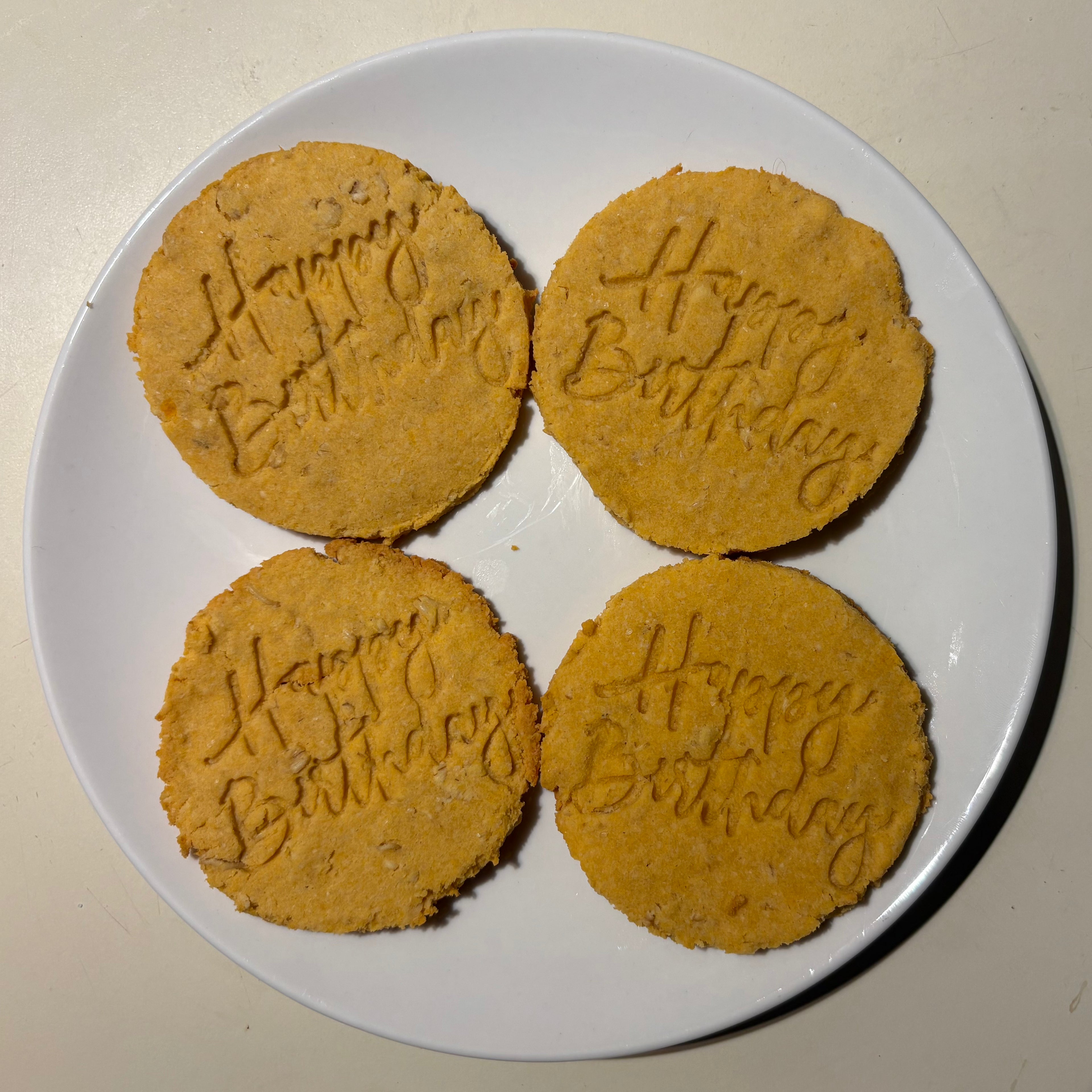circular dog treat with happy birthday stamped on it