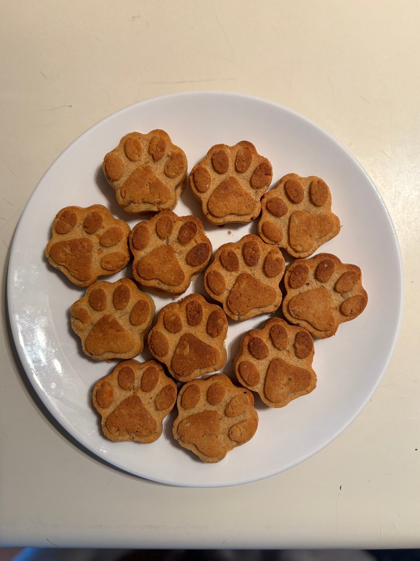 Paw shape sweet potato natural dog treats on a white plate