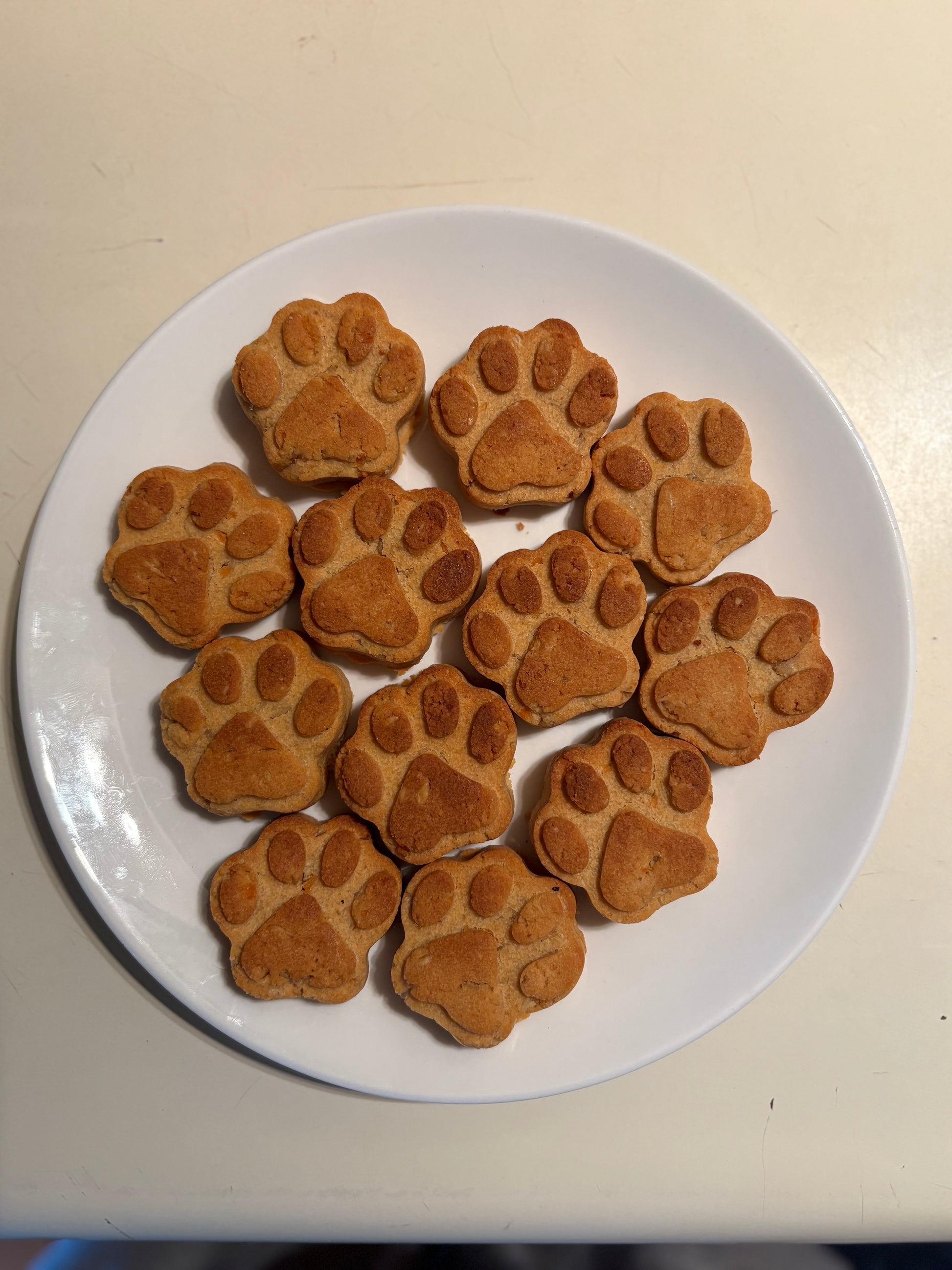 Paw shape sweet potato natural dog treats on a white plate