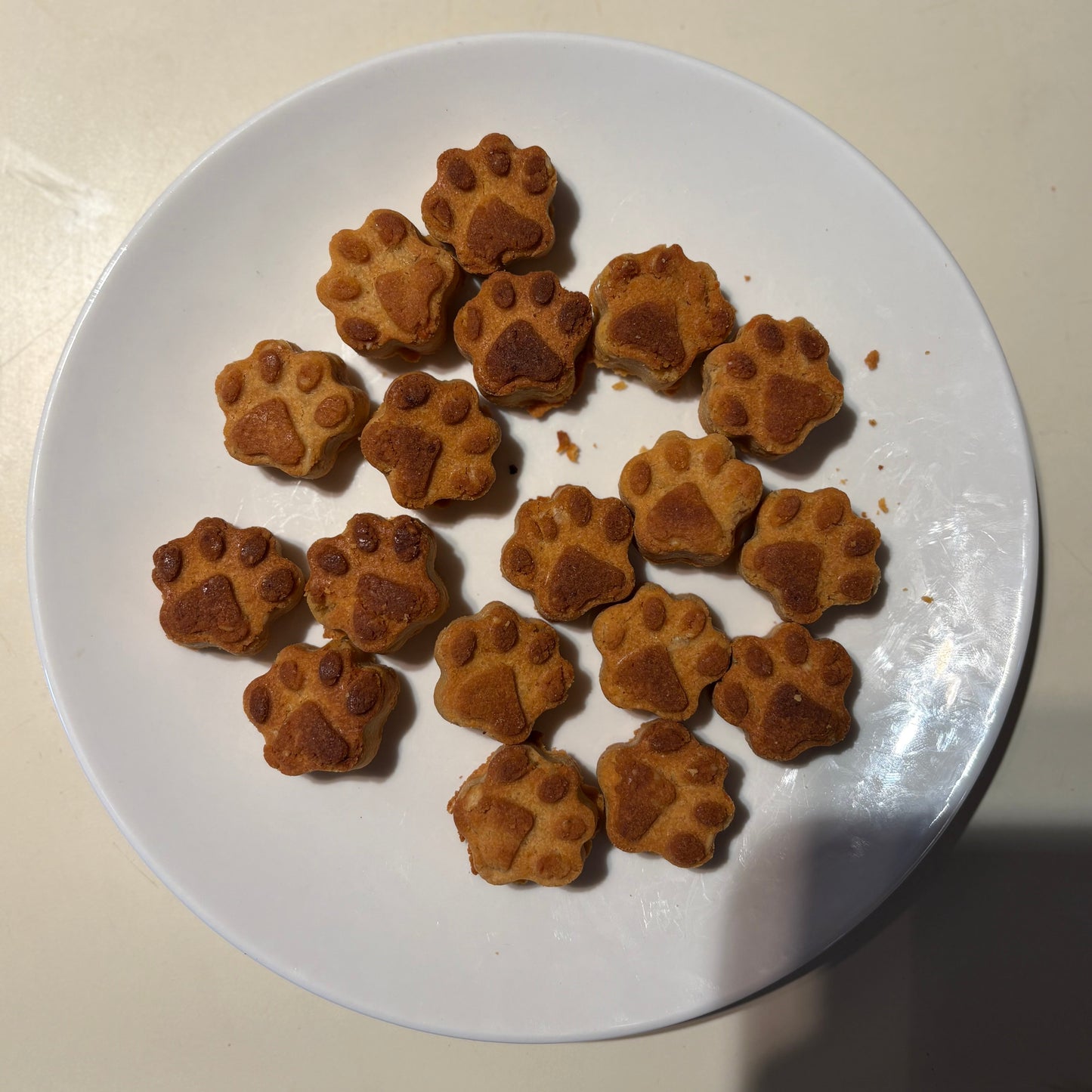 Paw shape sweet potato natural dog treats on a white plate