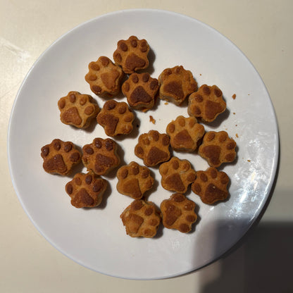 Paw shape sweet potato natural dog treats on a white plate