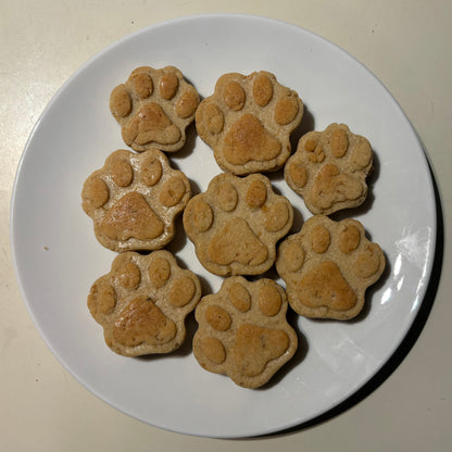 Paw shape salmon natural dog treats on a white plate