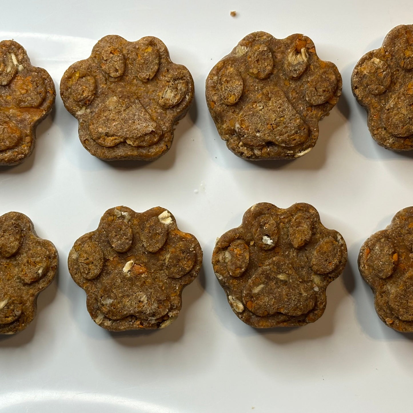 Dog treats shaped like paw prints on a white plate