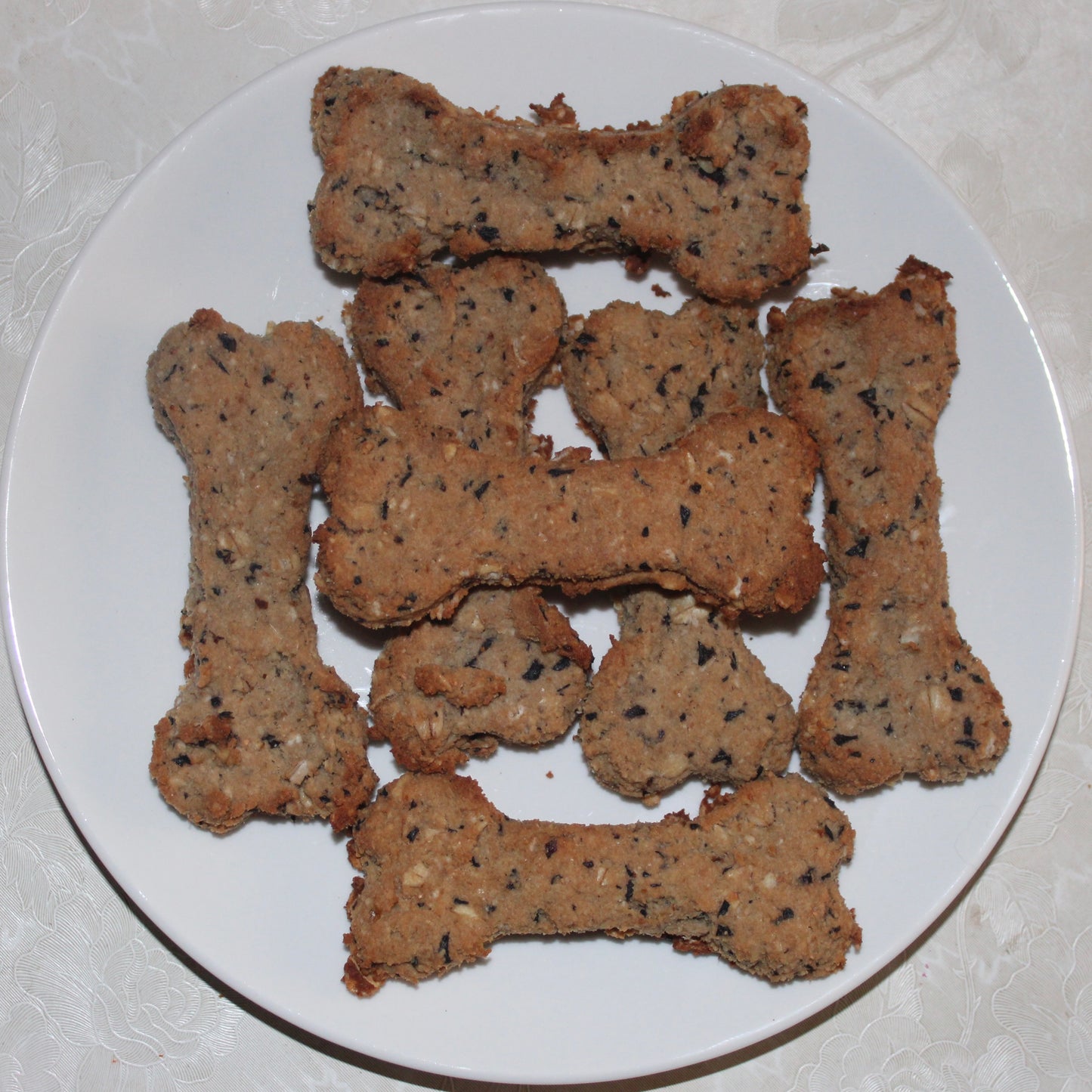 bone shaped blueberry natural dog treats on a white plate