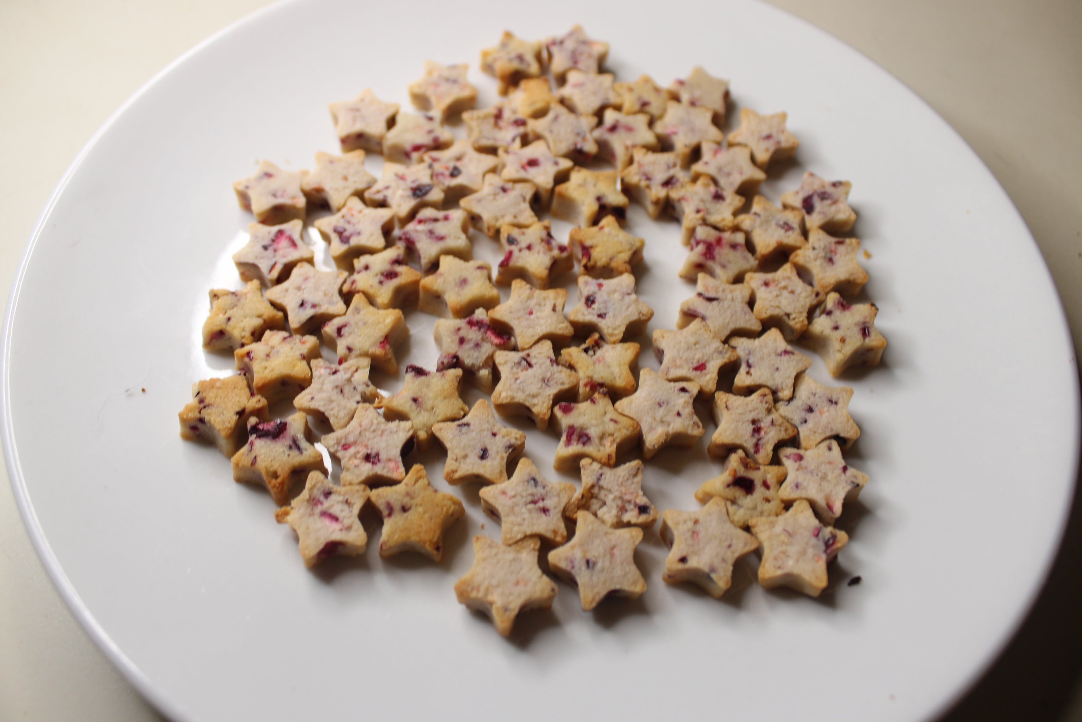 Star-shaped cranberry cat treats on a white plate
