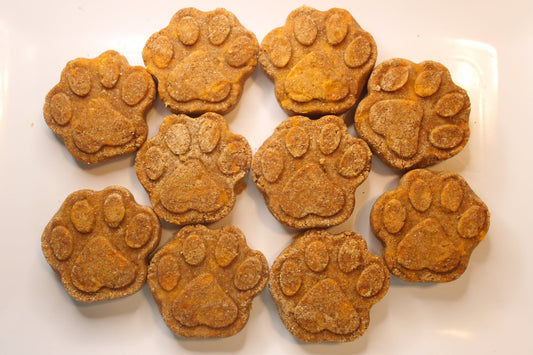 Dog treats shaped like paw prints on a white plate